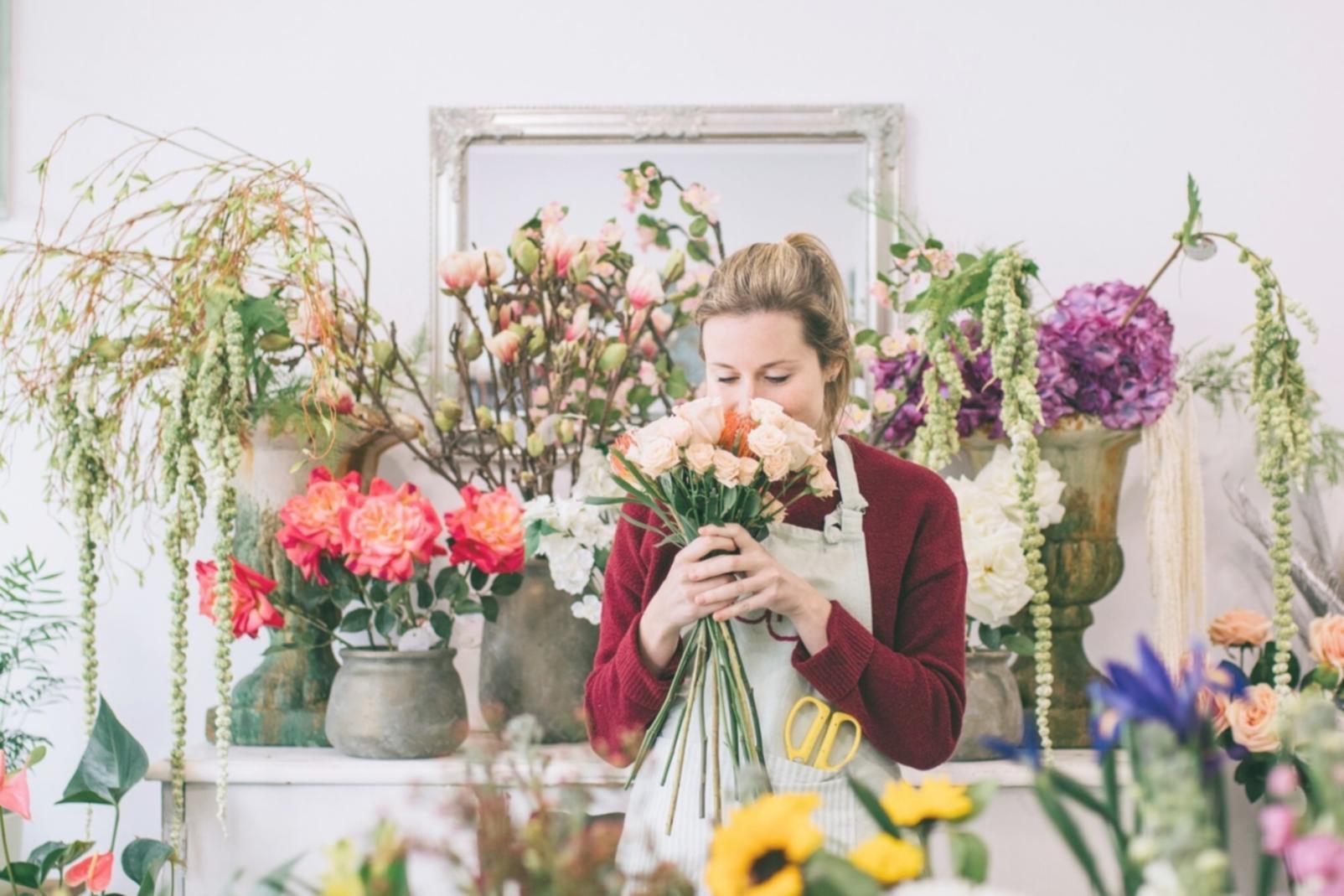 Instructor demonstrating floral arrangement technique to a small group